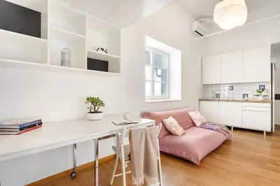 a living room with a pink couch and a table at Modern studio apartment in the heart of old city in Ljubljana