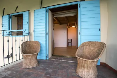 two wicker chairs sitting on the front porch of a house at Pri Bregarju in Podsabotin