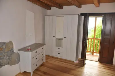 a bedroom with a white dresser and a sliding door at Pri Bregarju in Podsabotin