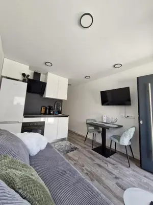 a room with a bed and a table and a kitchen at Livada in Ljubljana