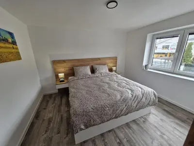 a white bedroom with a bed and a window at Livada in Ljubljana