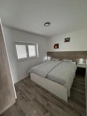 a bedroom with a bed and a wooden floor at Livada in Ljubljana