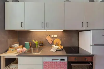 a kitchen with white cabinets and a sink at Casa1895, Stylish Old Town Apartment near Beer Fountain in Žalec