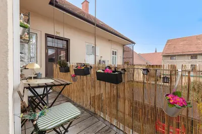 a balcony with potted plants on a wooden fence at Casa1895, Stylish Old Town Apartment near Beer Fountain in Žalec