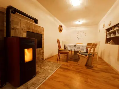 a living room with a fireplace and a table at Sigma house in Mojstrana