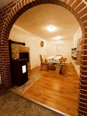 a living room with a brick fireplace and a table at Sigma house in Mojstrana