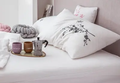 a bed with white pillows and two cups on it at Peaceful Stay Among the Vines in Vipolže