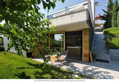 a house with a chair sitting outside of it at Peaceful Stay Among the Vines in Vipolže