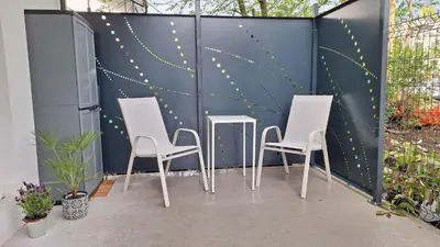 four chairs and a table against a wall at Apartment GA-JA in Ljubljana