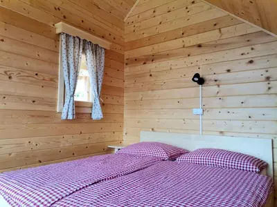 a bedroom with a bed in a wooden room at Scenic Glamping Huts with Mountain Views near Ljubno ob Savinji, Slovenia in Mozirska Koča