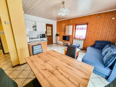 a living room with a table and a blue couch at Apartma Jakob 2 in Bovec