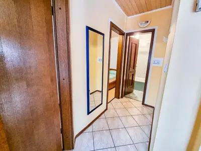 a hallway with a door and a mirror at Apartma Jakob 2 in Bovec