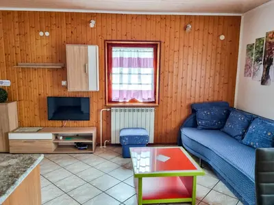 a living room with a blue couch and a tv at Apartma Jakob 2 in Bovec