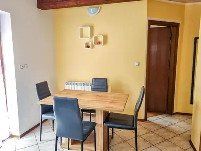 a dining room with a wooden table and chairs at Apartma Jakob 2 in Bovec