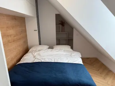 a room with a bed in the middle of a attic at Apartma Tyrseva in Maribor