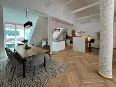 a dining room and living room with a table and chairs at Apartma Tyrseva in Maribor