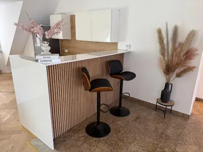 a room with two bar stools and a counter at Apartma Tyrseva in Maribor