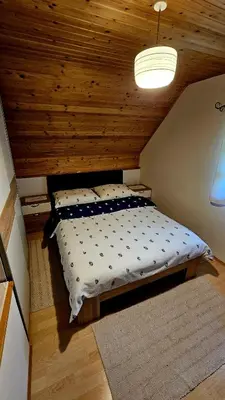 a large bed in a room with a wooden ceiling at Country House Srček in Bizeljsko