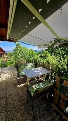 a table and chairs under an umbrella on a patio at Country House Srček in Bizeljsko