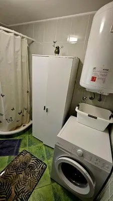 a bathroom with a washing machine and a white cabinet at Country House Srček in Bizeljsko