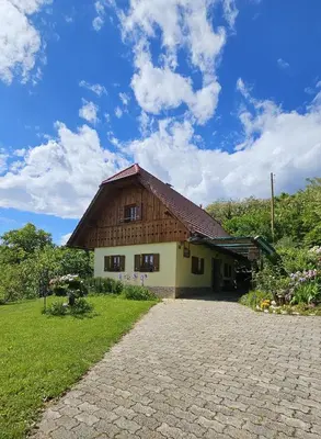 a house with a thatched roof on a field at Country House Srček in Bizeljsko