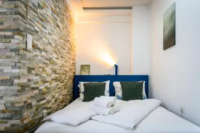 a bedroom with a bed with a brick wall at The Cosy Loft in Ljubljana