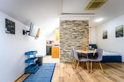 a room with a table and chairs and a brick wall at The Cosy Loft in Ljubljana