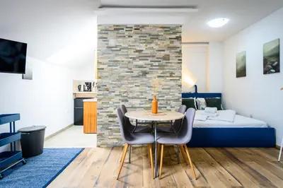 a room with a bed and a table and chairs at The Cosy Loft in Ljubljana