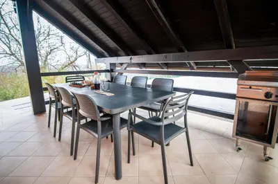a black dining table and chairs on a patio at Holiday house David in Podčetrtek