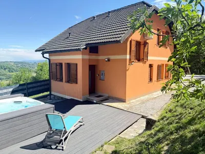 a house with a pool and a chair on a deck at Holiday house David in Podčetrtek