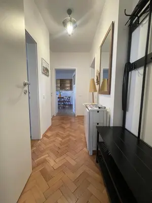 a living room with a wooden floor and a hallway at At the Burkulis' in Ljubljana
