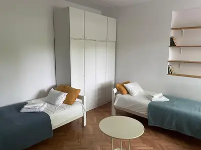 a living room with two beds and a table at At the Burkulis' in Ljubljana