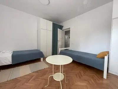 a room with two beds and a table and a bed at At the Burkulis' in Ljubljana