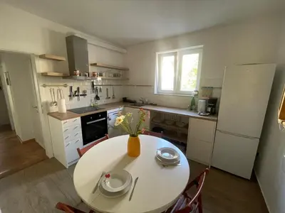 a kitchen with a table with a vase of flowers on it at At the Burkulis' in Ljubljana