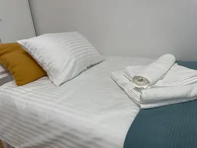 a white bed with two pillows on top of it at At the Burkulis' in Ljubljana
