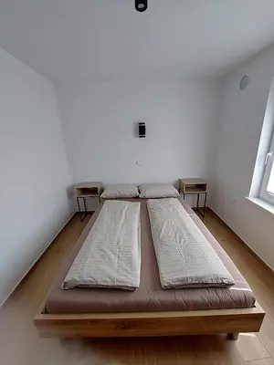 a large bed in a room with two windows at Apartma 47 in Kobarid