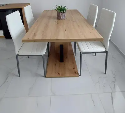 a wooden table with white chairs and a potted plant on it at Apartma 47 in Kobarid