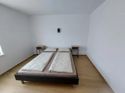 a large bed in a white room with two tables at Apartma 47 in Kobarid