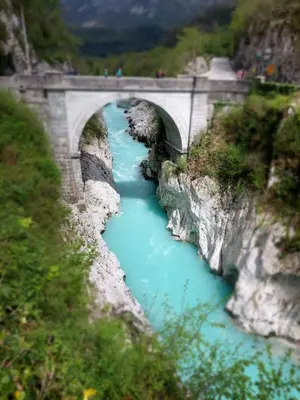 a bridge over a river with blue water at Apartma 47 in Kobarid