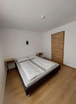 a bedroom with a large bed and a wooden door at Apartma 47 in Kobarid