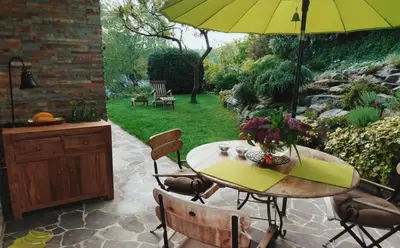 a table with a yellow umbrella on a patio at Peaceful Heartwarming Home With A Green Terrace in Maribor