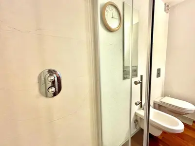 a bathroom with a toilet and a clock on the door at Peaceful Heartwarming Home With A Green Terrace in Maribor