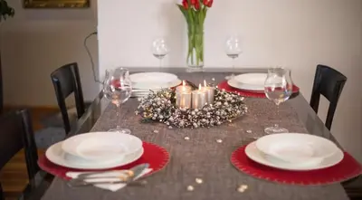a table with plates and wine glasses and a christmas centerpiece at Peaceful Heartwarming Home With A Green Terrace in Maribor