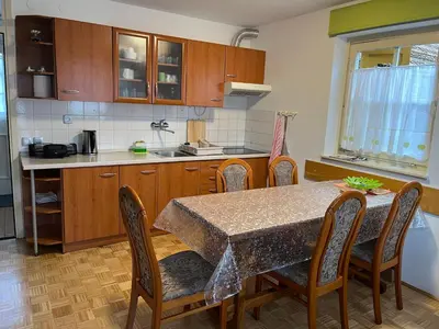 a kitchen with a table and chairs and a counter top at Mirni kotiček in Čatež ob Savi