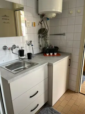 a small kitchen with a sink and a mirror at Mirni kotiček in Čatež ob Savi