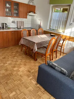 a kitchen with a table and chairs and a couch at Mirni kotiček in Čatež ob Savi