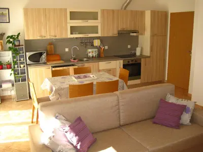 a living room and kitchen with a couch and a table at Apartment House Cviter in Bovec