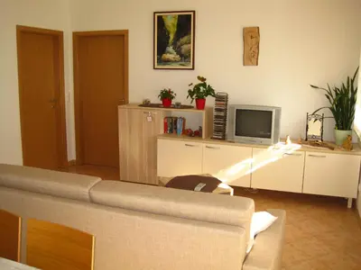 a living room with a couch and a tv at Apartment House Cviter in Bovec