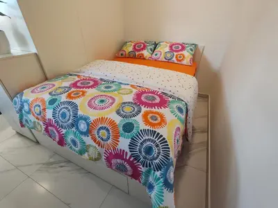 a bed with a colorful comforter and two pillows at Studio Hathor - Bikers Welcome in Kranj