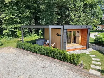 a small shed in a garden with a bench at DESIREE with Sauna&HotTube at Potatoland Lux Resort in Šenčur